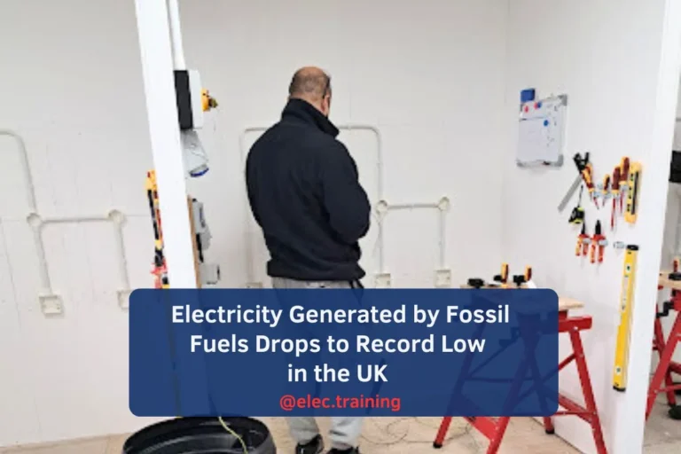 Electrician standing in a training booth with wall-mounted electrical practice installations