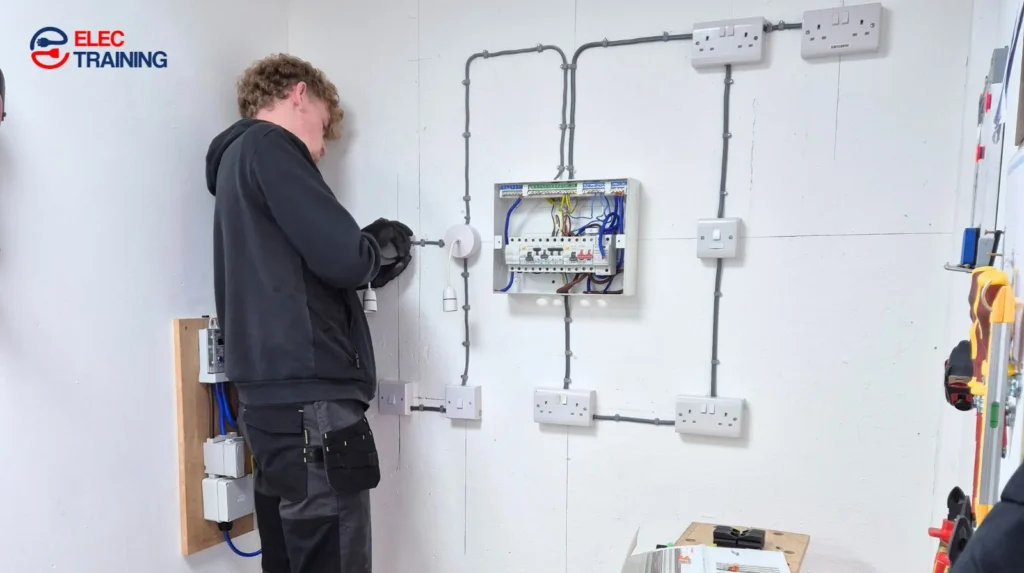 Adult learner completing hands-on electrical wiring practice at Elec Training workshop.