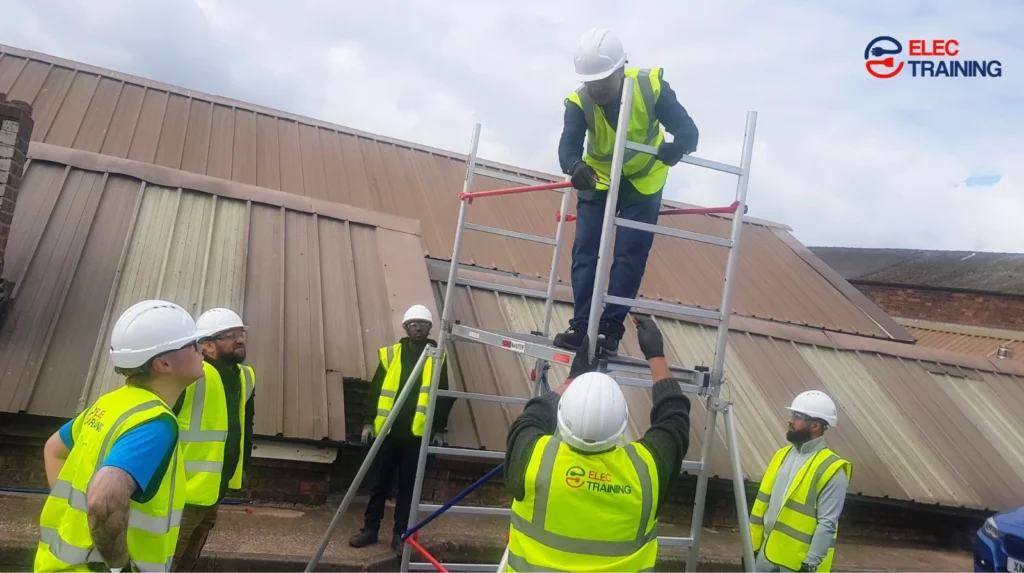 Adult learners wearing safety helmets and high-visibility vests complete hands-on electrical training using access equipment at an Elec Training facility.